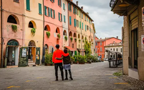 Coppia abbracciata in una strada con case colorate, un assaggio dei paesi belli vicino Ravenna.