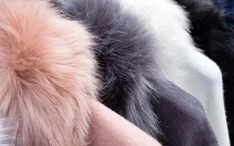 Weiche Kunstfell-Pompons in Rosa, Grau und Weiß. Ideal für Mützen, die man waschen kann.