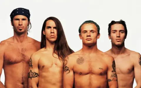Les membres des Red Hot Chili Peppers, torse nu, posent pour une photo. L'âge ne semble pas avoir d'emprise sur leur énergie.