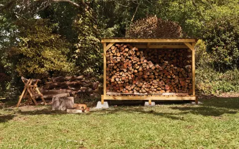 Abri bois de chauffage fait maison, rempli de bois sec. Un chien se repose à l'ombre.