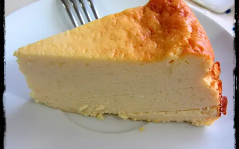 Una rebanada de tarta de queso light, con su dorada superficie y cremosa textura, lista para disfrutar.