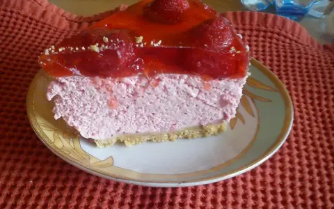 Pyszna pianka truskawkowa z galaretką i owocami, podana na talerzyku.