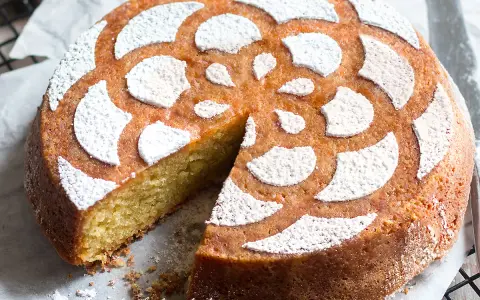 Deliziosa caprese al limone, soffice e profumata, con decorazione a fiore di zucchero a velo.