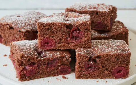 Saftiger schoko kirsch kuchen blech, bestäubt mit Puderzucker. Ein Genuss für jeden Anlass!