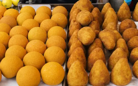 Arancini e arancine dorati, pronti per essere gustati. Un tripudio di sapori siciliani.