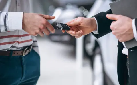 Un hombre entrega las llaves de un coche para una tasación de vehículo.