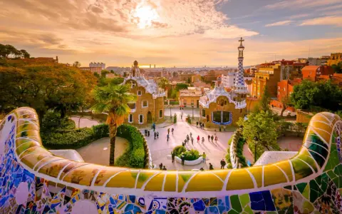Kolorowy park Güell w Barcelonie, jednym z najpiękniejszych miast w Hiszpanii, zachwyca mozaikową ławką i bajkowymi budynkami.