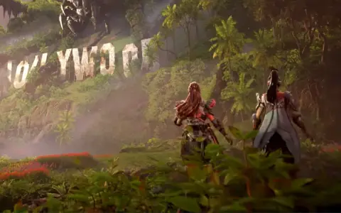 Aloy i jej towarzyszka przemierzają bujną dżunglę w Horizon Forbidden West: Burning Shores, mijając zniszczony napis Hollywood.