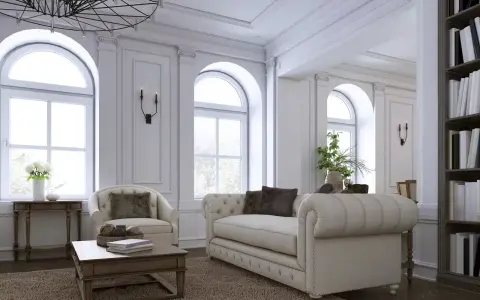 Elegancki salon z sofą, fotelem i książkami na półce.