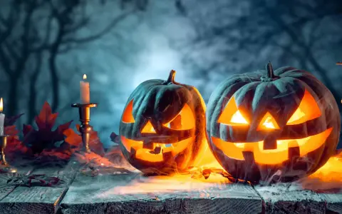 Zwei gruselige Kürbisse leuchten im Nebel, umgeben von Kerzen und Herbstlaub. Die wahre Bedeutung von Halloween liegt in dieser unheimlichen Atmosphäre.
