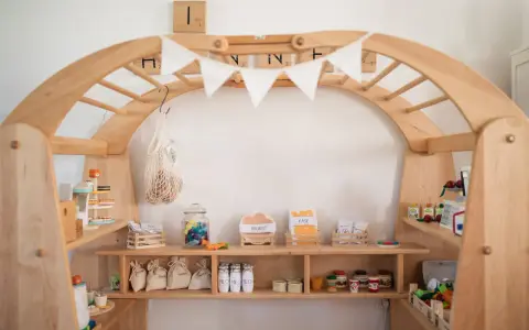 Ein liebevoll gestalteter Kaufladen zum selber bauen, gefüllt mit Spielzeug-Lebensmitteln wie Wurst, Käse, Zucker und Milch.