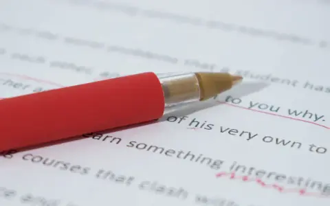 Czerwony długopis poprawia tekst, podkreślając "to you why". Czy przed "ze względu" stawiamy przecinek? To pytanie, na które szukamy odpowiedzi.