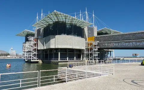 Das moderne Aquarium Lissabon ragt mit seinen Glasdächern und Betonstrukturen über dem Wasser auf.