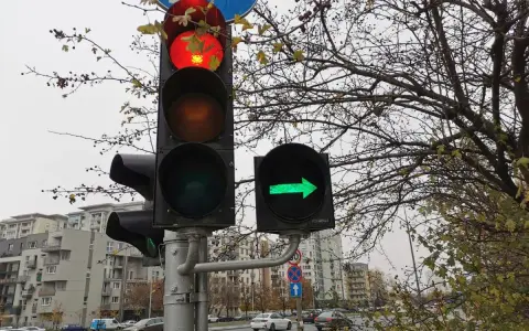Sygnalizacja świetlna: czerwone światło główne i zielona strzałka warunkowa w prawo.
