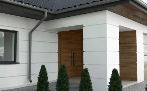 Nowoczesna elewacja z białym tynkiem i drewnianymi akcentami. Charakterystyczne boniowanie na elewacji podkreśla geometryczne kształty budynku.