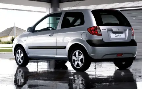Srebrny Hyundai Getz 1.1 z czarnymi listwami, odbijający się w mokrej nawierzchni pod zadaszeniem.