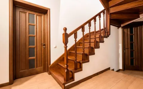 Scala interna in legno scuro con porte abbinate. Idee pittura scala interna: il legno caldo crea un'atmosfera accogliente.