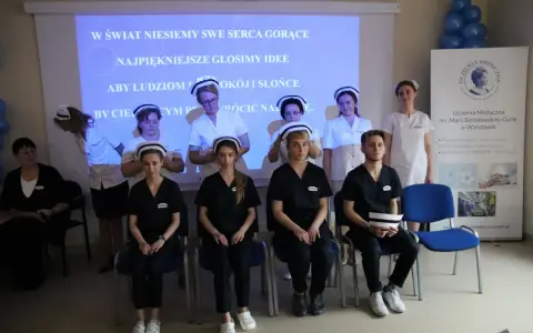 Uczelnia Medyczna im. Marii Skłodowskiej-Curie w Warszawie: studenci w strojach medycznych, z hasłem na ekranie.