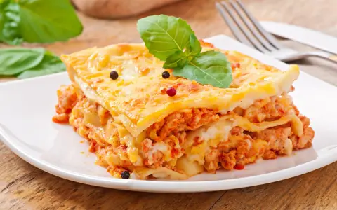 Pyszna lasagne z mięsem i serem, ozdobiona bazylią i pieprzem. Idealna na obiad, czy to lasagne czy cannelloni, smakuje wybornie.