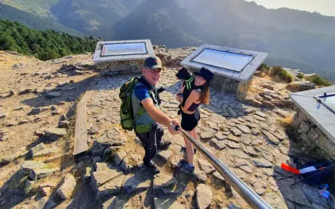 Pareja y perro posan en la barranca mirador de las canchas, disfrutando de las vistas montañosas.