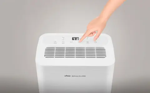 Mano ajustando la velocidad en un deshumidificador Ufesa Wellness Dry 2000. Guía para saber como elegir un deshumidificador.