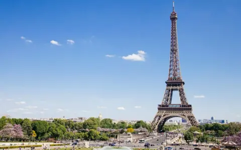 Eiffelturm in Paris, mit Menschen im Park. Hier gibt es viele Paris Tipps und Tricks für Ihren Besuch.