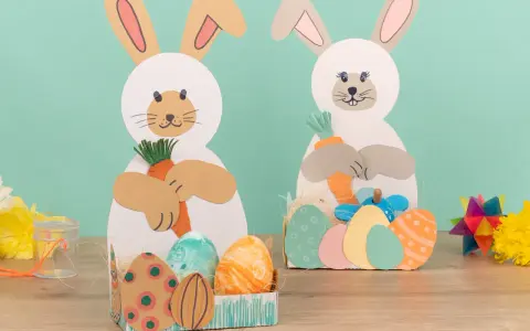 Zwei süße Osterhasen halten Karotten. Kinder haben diese tollen Osterdeko zum Thema Osternest basteln Kinder selbst gemacht.