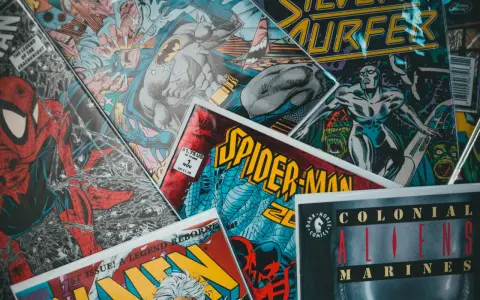 Stos komiksów z postaciami takimi jak Spider-Man, Batman i Silver Surfer. Czy komiks to książka? To zależy od tego, jak na to spojrzeć!