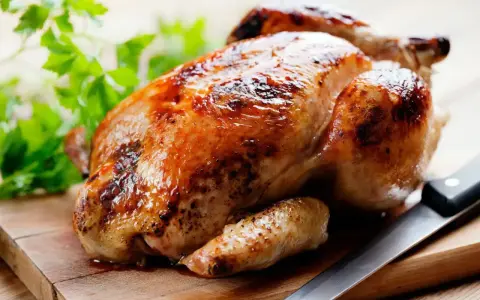 Un appétissant poulet rôti sur une planche en bois, prêt à être dégusté. Quel vin avec poulet rôti ? Un blanc fruité ou un rouge léger serait parfait.