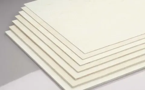 Mehrere dünne Platten aus hellem **Birkensperrholz** liegen übereinander.