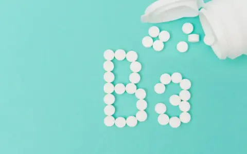 Des pilules blanches forment le "B3" sur fond turquoise. La vitamine B3, c'est quoi ? C'est essentiel pour votre corps.