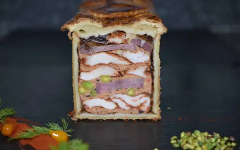 Pâté en croûte aux multiples couches de viandes, pistaches et gelée. Une œuvre d'art culinaire digne de la recette du meilleur pâté en croûte du monde.