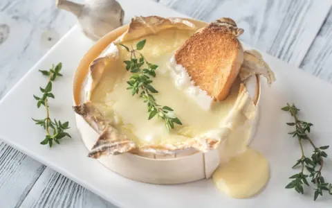 Un camembert coulant, spécialité normandie, servi avec du pain grillé et du thym. Un délice !