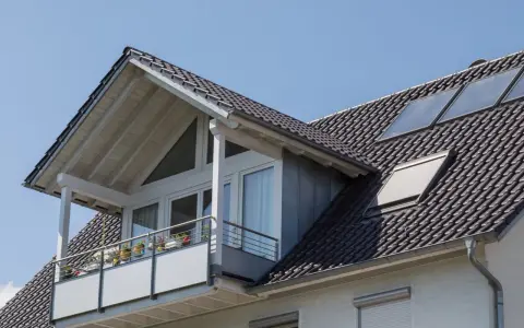 Dachgaube mit Balkon und Solarpaneelen. Informieren Sie sich über Dachgaube Kosten für Ihr Zuhause.
