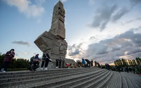 Uroczystość przy Pomniku Obrońców Wybrzeża na Westerplatte w Gdańsku. Warty honorowe, wieńce i zgromadzeni ludzie.