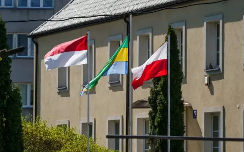 Trzy flagi powiewają przed budynkiem: biało-czerwona flaga Polski, flaga Monako (identyczna jak Indonezji) i flaga Gabonu.