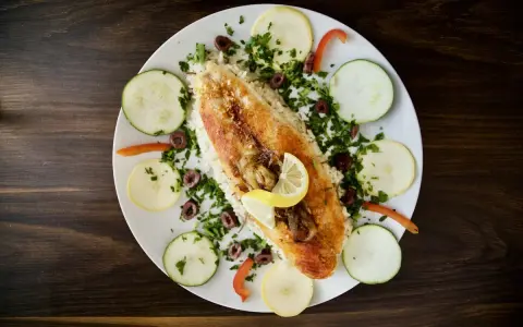 Ryba z ryżem, cytryną, oliwkami i warzywami. Pyszne danie w stylu dieta śródziemnomorska.