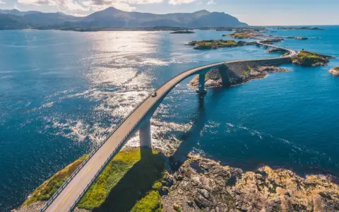 En bil kör över en bro i Norge, en del av den fantastiska Atlantvägen. En dröm att åka till Norge och uppleva detta!
