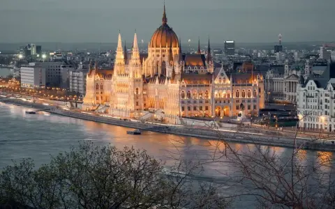 Budapeszt na weekend: majestatyczny Parlament oświetlony nocą, odbijający się w Dunaju. Idealne miejsce na romantyczny wypad.