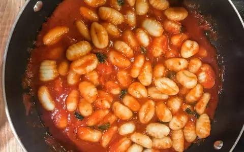 Pyszne gnocchi w aromatycznym sosie pomidorowym z ziołami, gotowe do podania. Idealny sos do gnocchi na szybki obiad.