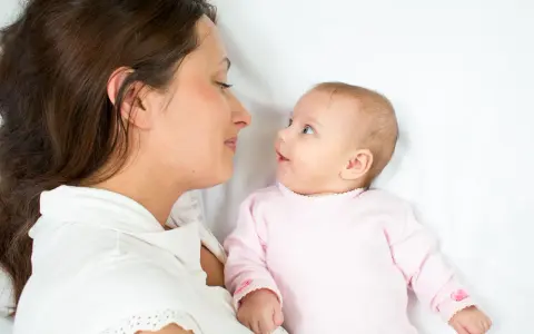 Mama patrzy na swoje dziecko, kiedy noworodek widzi świat po raz pierwszy.
