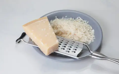 Kawałek sera i tarka na talerzu. Szukasz, czym zastąpić parmezan? Oto inspiracja!