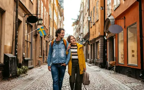Ein Paar spaziert durch eine Gasse in Stockholm. Das Wetter in Schweden im September ist mild, perfekt für Sightseeing.