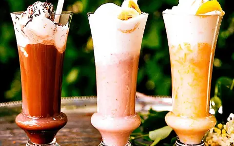 Tre läckra milkshakes i glas: choklad, jordgubb och aprikos. Perfekt för ett somrigt milkshake recept.