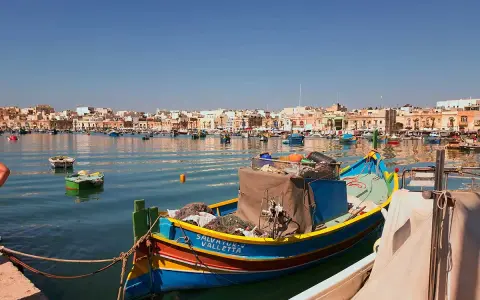 Färggranna fiskebåtar i hamnen, en dröm om att flytta till Malta.