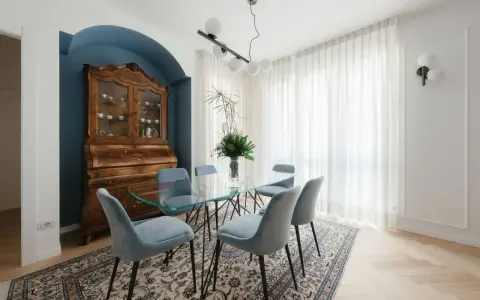 Un soggiorno classico con un mobile antico e un tavolo in vetro. I colori delle pareti, un blu intenso, creano un'atmosfera elegante.