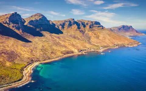 Bergige Küste bei Kapstadt mit türkisfarbenem Wasser und einem einsamen Strand.