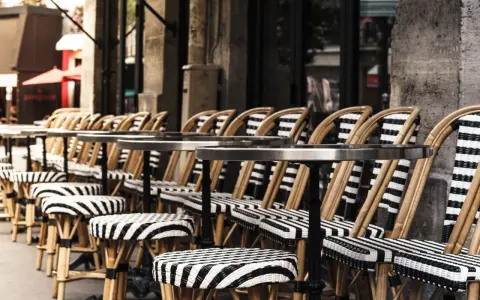 Terrasses parisiennes avec chaises et tabourets rayés, prêts à accueillir les gourmands pour déguster les spécialités paris.