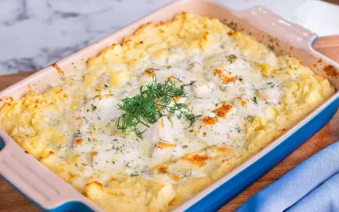En krämig fiskgratäng med potatismos, perfekt för ett alaska pollock recept. Garnerad med färsk dill.
