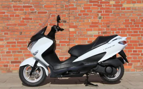 Biały skuter Suzuki Burgman 125, idealny do miasta, z niskim spalaniem.
